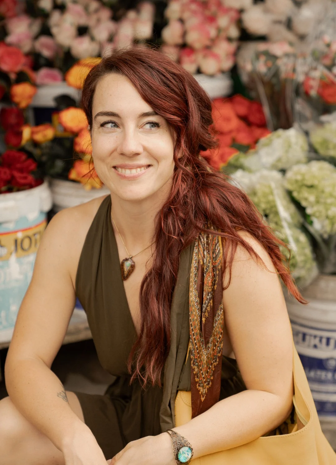 Chanti Zak, smiling, seated at a flower market.